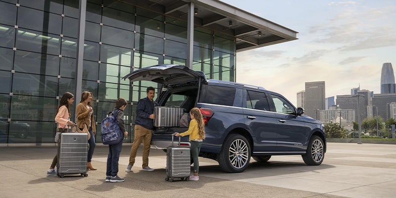 A frailly on their way to the airport filing up their brand new 2023 Ford Expedition with an abundance of luggage. 