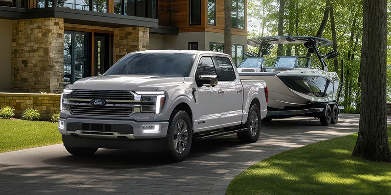 White Ford truck towing a boat.